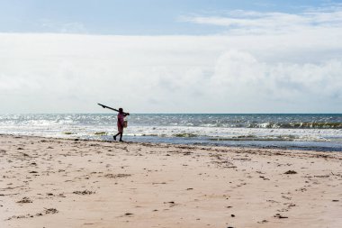 Fisherman is seen walking on the beach. Guaibim beach in the city of Valenca, Bahia, Brazil.