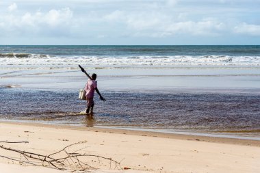 Fisherman is seen walking on the beach. Guaibim beach in the city of Valenca, Bahia, Brazil.