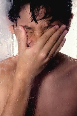 Eğlenceli ve mutlu çocuk suyun altında dururken banyonun tadını çıkarıyor. Çocuk evde sağlıklı bir çocukluk geçiriyor..