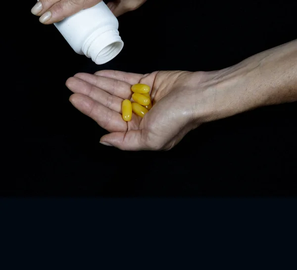 One Hand Pours Yellow Pills Palm Another Hand Black Background — 스톡 사진
