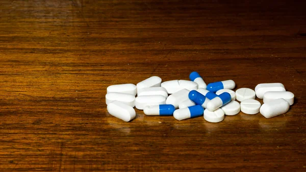 Simple Pile White Blue Pills Medicines Pills Stacked Brown Background — стоковое фото