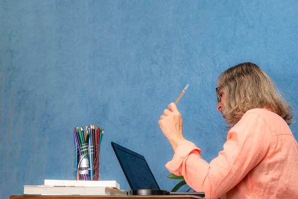 Sideways woman with laptop computer working at home or office. Business, people and technology concept.