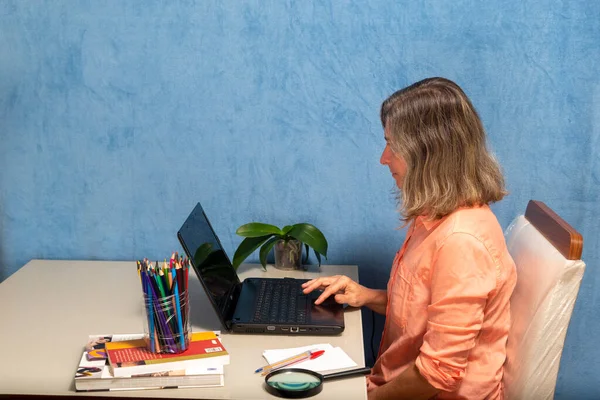 Sideways woman with laptop computer working at home or office. Business, people and technology concept.