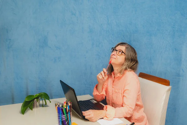 Thoughtful and worried woman with laptop computer working from home or office. Business, people and technology concept.