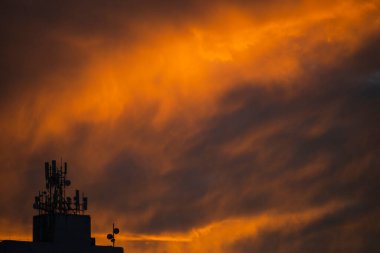 Turuncu renkli dramatik günbatımına karşı siluet ve televizyon antenleri inşa etmek. Güzel bir öğleden sonra. Salvador, Bahia, Brezilya.