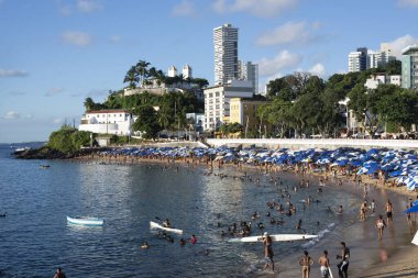 Salvador, Bahia, Brezilya - 09 Nisan 2022: Brezilyalılar ve turistler güneşli bir öğleden sonra Salvador 'daki Porto da Barra plajında banyo yapıyorlar.
