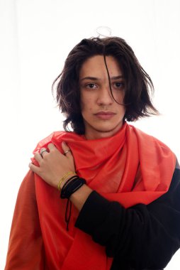 Omzunda beyaz arka planda kırmızı şeffaf kumaş olan genç bir adam. Stüdyo fotoğrafçılığı. Salvador, Brezilya.