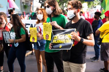 Salvador, Bahia, Brezilya - 09 Nisan 2022: Aşırı sağ başkan adayı Jair Bolsonaro 'yu protesto eden Brezilyalılar. Sloganlı posterler, bayraklar ve pankartlar kullanıyorlar..