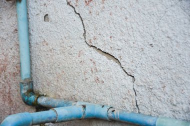 Beyaz beton duvardaki çatlaklar