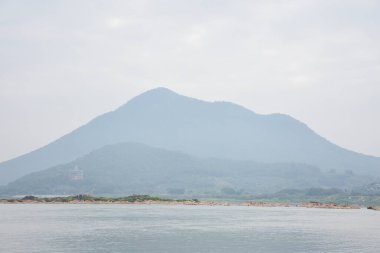 Yağmurlu bir günde dağ ve nehir manzarası