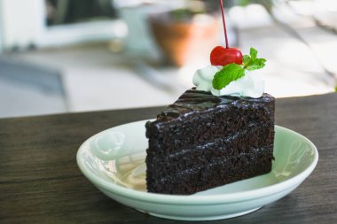 Closeup of chocolate cake in a plate on a wooden table