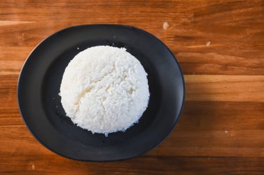 Masadaki siyah tabakta sade pirinç yemeye hazır..