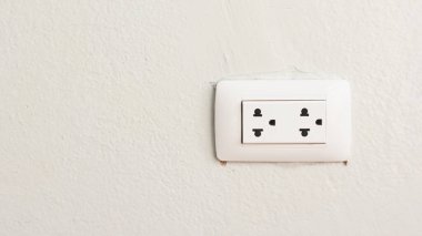 Beton bir duvarda beyaz bir güç prizine yakın plan