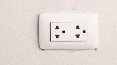 Beton bir duvarda beyaz bir güç prizine yakın plan