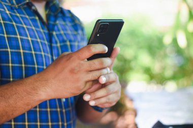 kahve dükkanında cep telefonu kullanan adam