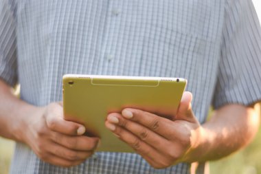 Bilgi kontrol etmek için bir tablet kullanan bir iş adamı eli