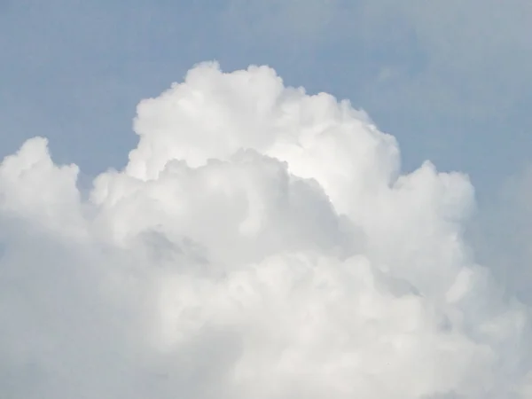 A blue sky with a white cloud at noon has a place for text.