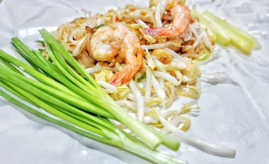 Tayland yemeği, Tayland 'daki sokak yemeklerinden beyaz kağıt üzerine kızarmış pirinç eriştesi (Pad Thai).