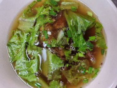 Beyaz bir fincanda tavuk kemiğinden temiz çorba ve birkaç tane de vejetaryen. bir noktaya odaklan