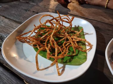 Beyaz tabakta baharatlı soslu kızarmış balık. Çıtır çıtır ve lezzetli. Atıştırmalık ya da meze olarak yenebilir..