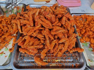 Tavuk kanatlarını baharatla kaplamak için tavuk kanatlarının tepesini kullanarak. Sıradan bir sokak yiyeceğidir. seçime odaklan.