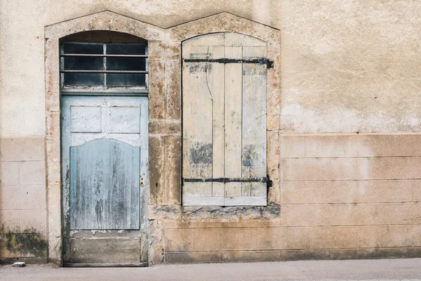 Eski bir kapı ve eski bir pencerenin manzarası. Terk edilmiş ve kapanmış eski bir evin manzarası. 