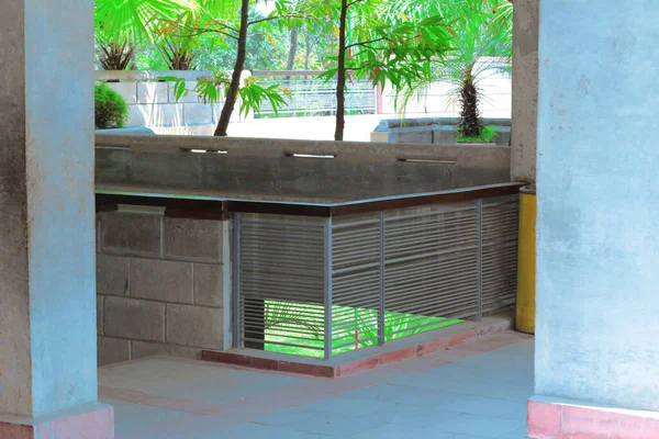 Metal parmaklıklı balkon koridoru. Dairenin ikinci katında parlak yeşil koridor, ahşap çerçeve metal parmaklık, tuğla duvar..