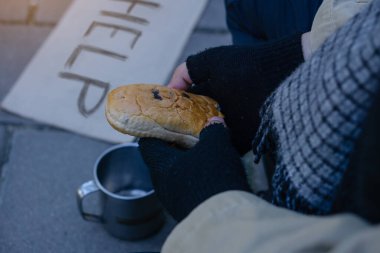 Dilenci, evsiz yetişkin bir adam sokakta yardım almak için oturuyor. İnsanların ilgisizliği. Sosyal meseleler. Mukavvaya yazmama yardım et..