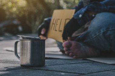 Dilenci, evsiz yetişkin adam parkta yardım almak için oturuyor. İnsanların ilgisizliği. Sosyal konular.
