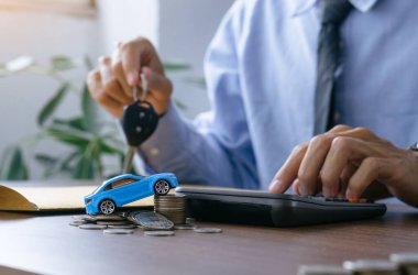 Tasarruf kavramı. Araba ve tamirat için para biriktiriyorum. Minyatür araba modeli, hesap makinesi ve madeni para beyannamesi..