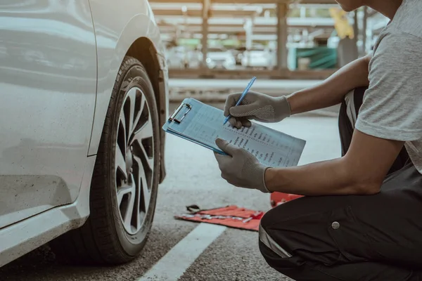 Tamirci Otomobil Garajında Araba Tekerleğini Kontrol Etmek Için Dosya Tutuyor — Stok fotoğraf