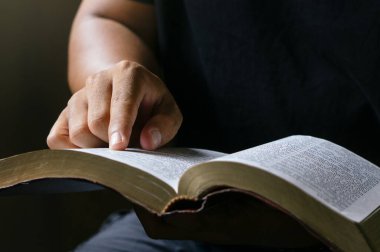 Young prayer sitting in chruch for reading bible and worship god, garden nature background. Bible concept.