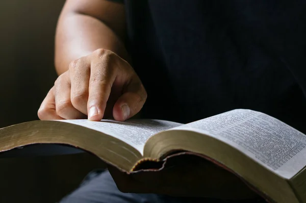 Young prayer sitting in chruch for reading bible and worship god, garden nature background. Bible concept.