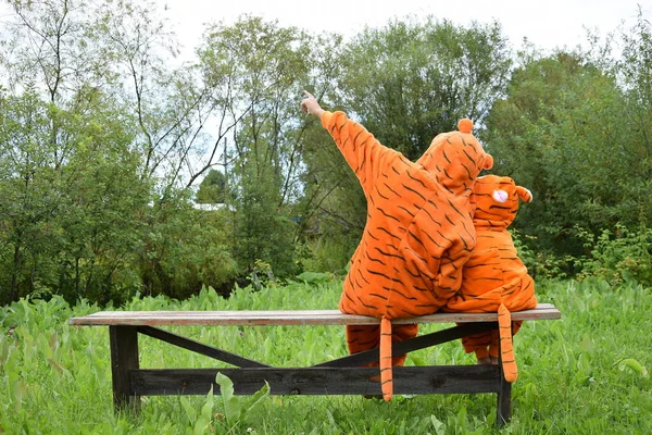 2022 'de kaplan kostümlü küçük çocuklar bahçede bir bankta kaplanın yeni yılını bekliyor, kaplan kuyruğu, yazı için yer, takvim için yer, not defteri, davetiye, reklam, gökyüzüne bakan kaplanlar.