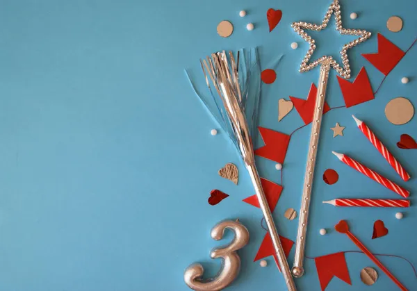 tatil aksesuarları, mavi arka plan, üst manzara, bayram, 3 yıl doğum günü pastadaki mumlar, 3 numara, parlak kırmızı bayraklar, çelenkler, tatil davetiyesi, bir kartpostal için arka plan, doğum günü, parlak bir yıldız, sihirli değnek, kopyalama alanı