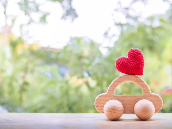 Red heart on wooden toy car for for transport and manage success business concept. Concept of car loan