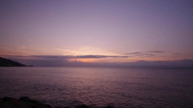 Sonbahar gününde denizin üzerinde yükselen güneş.