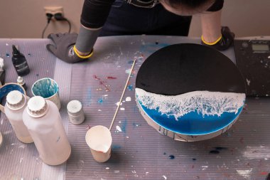 Epoksi reçine. Bir sanatçının tablosunu yapmak için yaratıcı bir hobi. Sıvı reçine sahtesi. Taş tahtada deniz taklidi.