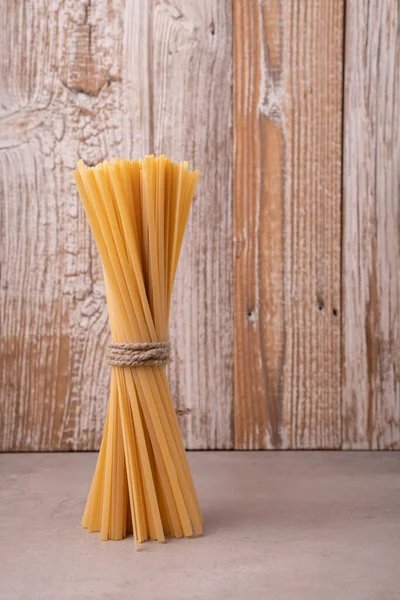 Ahşap arka planda çiğ spagetti.