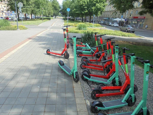 Ostrava, Çek - 07 13 2021: Ostrava elektrohareketlilik sahnesi geniş caddelerde ağaçlarla kaplı çoklu paylaşılan scooterlarla.