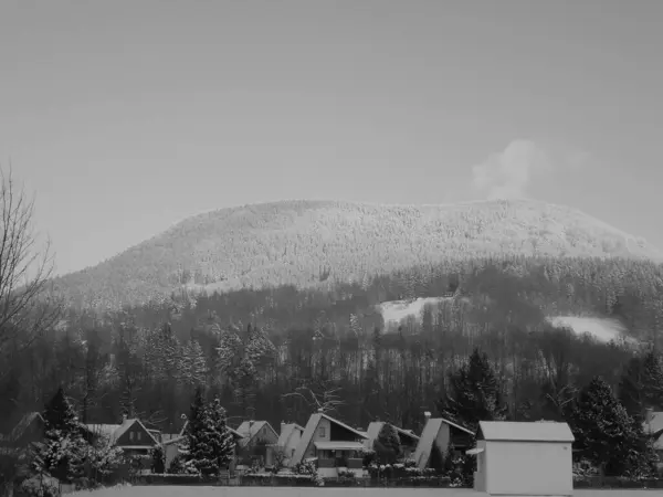 灰蒙蒙的图像 宏伟的山景 位于别斯基迪的捷克奥斯特荷拉山及其密密麻麻的云杉林覆盖着积雪 高耸在几个小村庄的房屋之上 — 图库照片