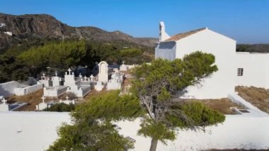 Yunan adasındaki küçük güzel bir köyün hava görüntüleri. Egzotik bir yer, mavi deniz, tepenin üstünde küçük bir kilise, mavi gökyüzü.