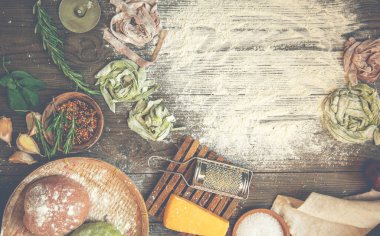 Kırsal arka planda makarna yapmak için gerekli malzemeler, üst manzara. Düz yatıyordu. İtalyan tarifi. El yapımı. Çiğ makarna yapma süreci. Taze İtalyan makarnası üretiyorum..
