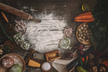 Kırsal arka planda makarna yapmak için gerekli malzemeler, üst manzara. Düz yatıyordu. İtalyan tarifi. El yapımı. Çiğ makarna yapma süreci. Taze İtalyan makarnası üretiyorum..