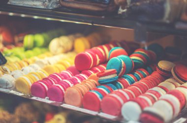 Pasta dükkanının cam vitrininde farklı tipte pastalar. Lezzetli şekerli bir gösteri. Fransa 'da bir şekerleme dükkanında sergilenen Fransız pastaları.