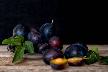 Köy arka planında yeşil yapraklı olgun erik. Olgun taze organik erikler..