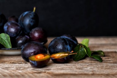 Köy arka planında yeşil yapraklı olgun erik. Olgun taze organik erikler..