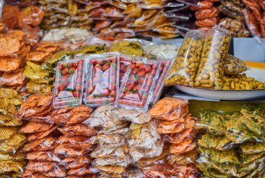 Organik yiyecekleri oyala. Çeşitli kurutulmuş besin maddeleri. Kurutulmuş ve taze meyveler bir büfede paketlenmiş. Endonezya 'daki çiftçi pazarı Bali' de organik taze tarım ürünü satmak.
