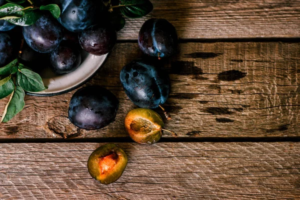 Köy arka planında yeşil yapraklı olgun erik. Olgun taze organik erikler..