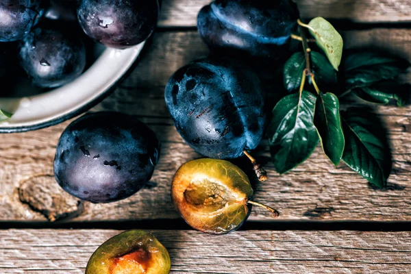 Köy arka planında yeşil yapraklı olgun erik. Olgun taze organik erikler..